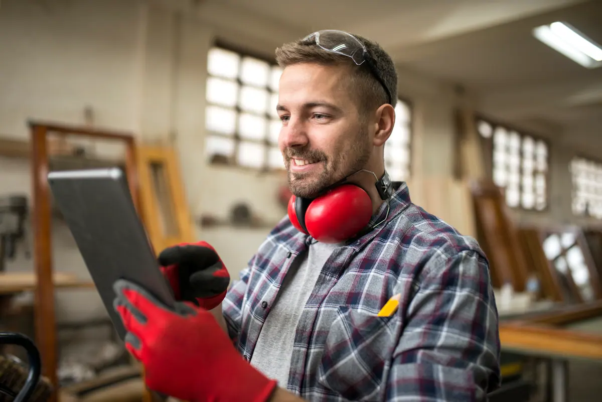 Independent carpenter using a tablet in his workshop